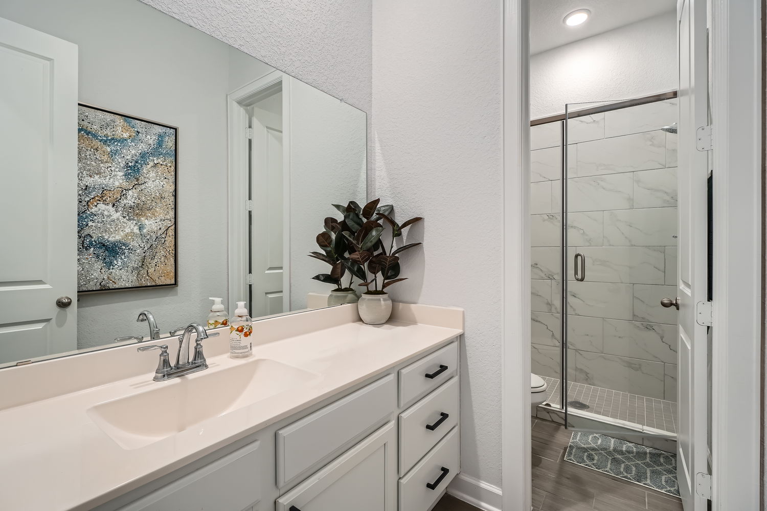 582 Wild Pecan Loop Buda, TX 78610 - Photo 17 of 28 Full bathroom with a marble finish shower, vanity, a textured wall, and dark wood-style flooring