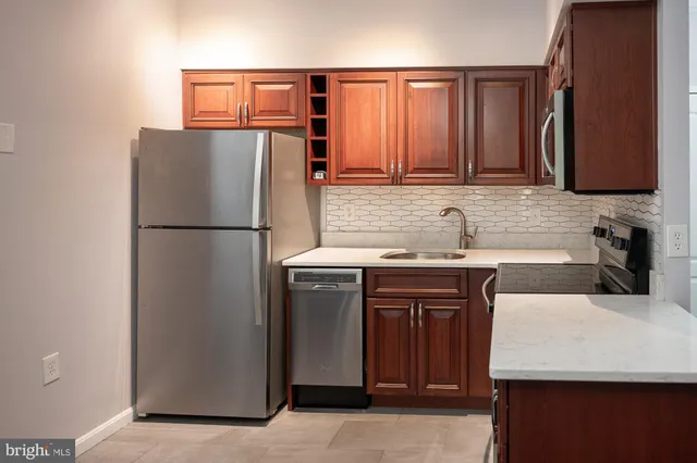 a kitchen with granite countertop a refrigerator and a sink