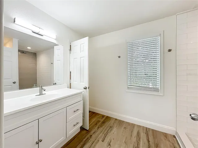a view of a bathroom with wooden floor and a window