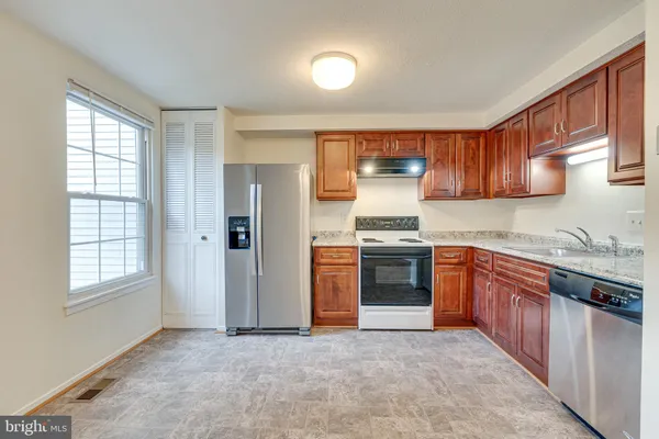 a kitchen with stainless steel appliances granite countertop a stove top oven sink and cabinets