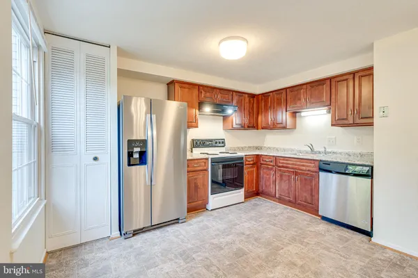 a kitchen with stainless steel appliances granite countertop a refrigerator sink and cabinets