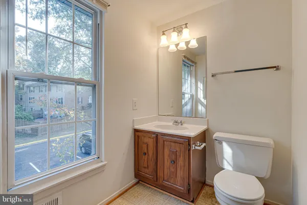 a bathroom with a toilet a sink and a large mirror