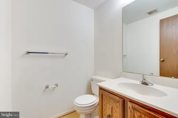a bathroom with a granite countertop sink toilet and a mirror