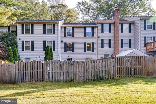 a front view of a house with a garden and trees