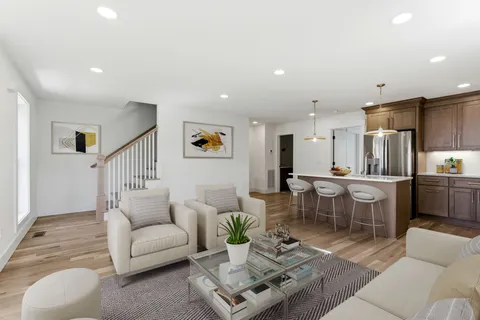 a living room with furniture and view of kitchen