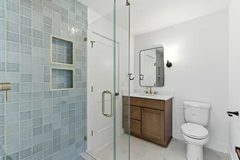 a bathroom with a sink a toilet and mirror