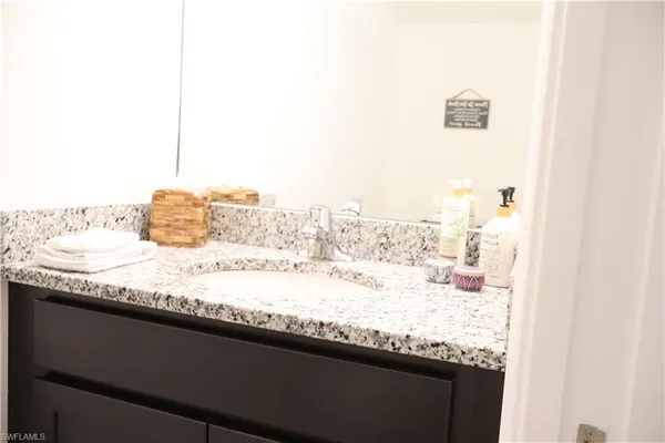 a bathroom with a granite countertop sink and a mirror