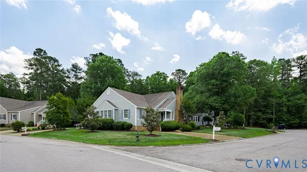 a front view of a house with a yard and trees