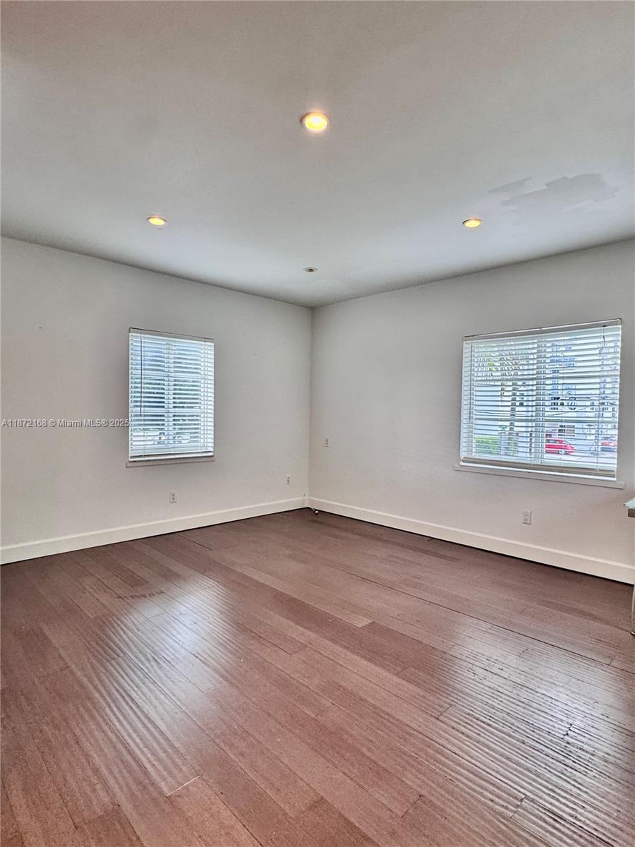 1231 13th Street, Unit 2 Miami Beach, FL 33139 - Photo 2 of 8 an empty room with wooden floor and windows