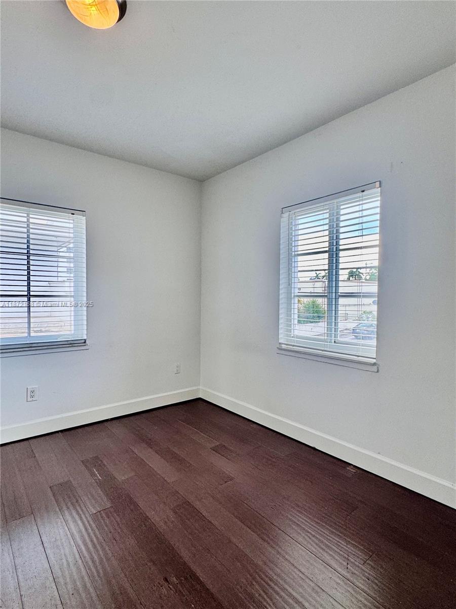 1231 13th Street, Unit 2 Miami Beach, FL 33139 - Photo 7 of 8 an empty room with wooden floor and windows