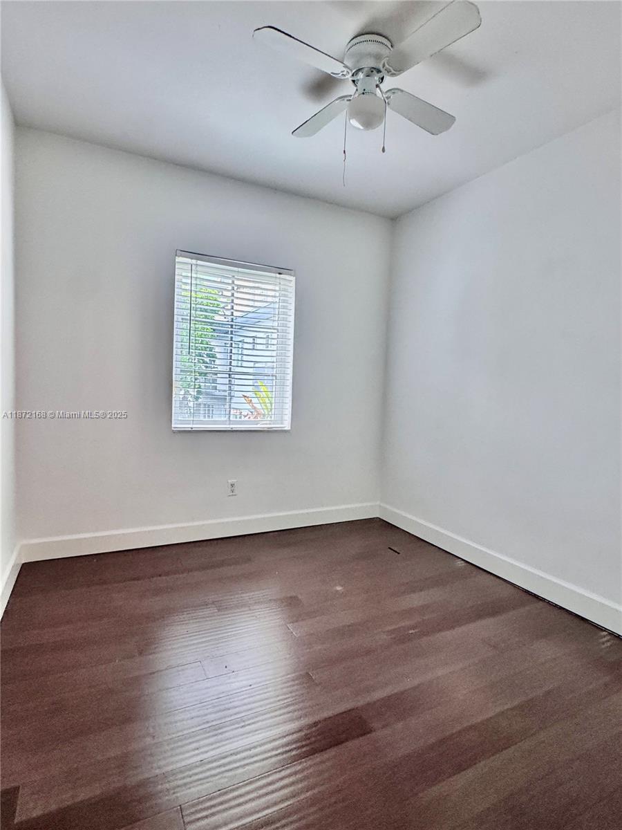 1231 13th Street, Unit 2 Miami Beach, FL 33139 - Photo 8 of 8 an empty room with wooden floor chandelier fan and windows