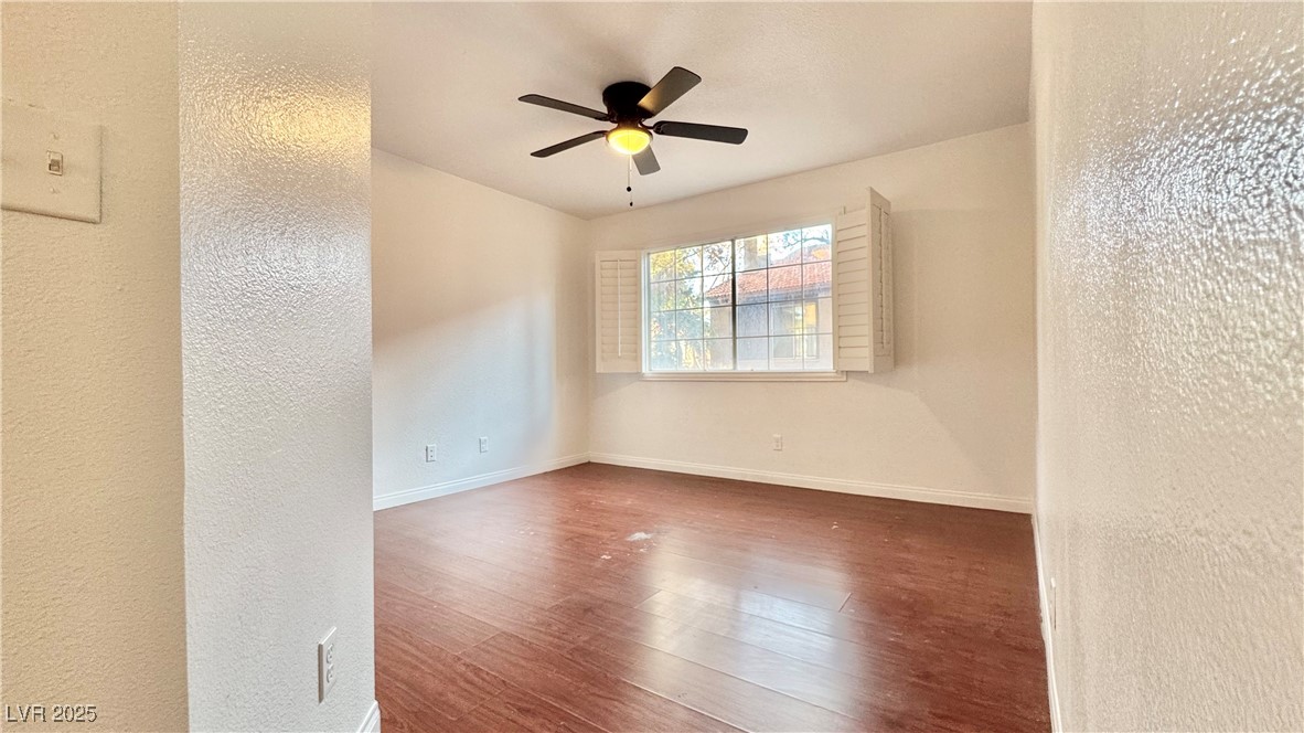 2750 South Durango Drive, Unit 2100 Las Vegas, NV 89117 - Photo 17 of 30 Unfurnished room with wood finished floors, a ceiling fan, and a textured wall