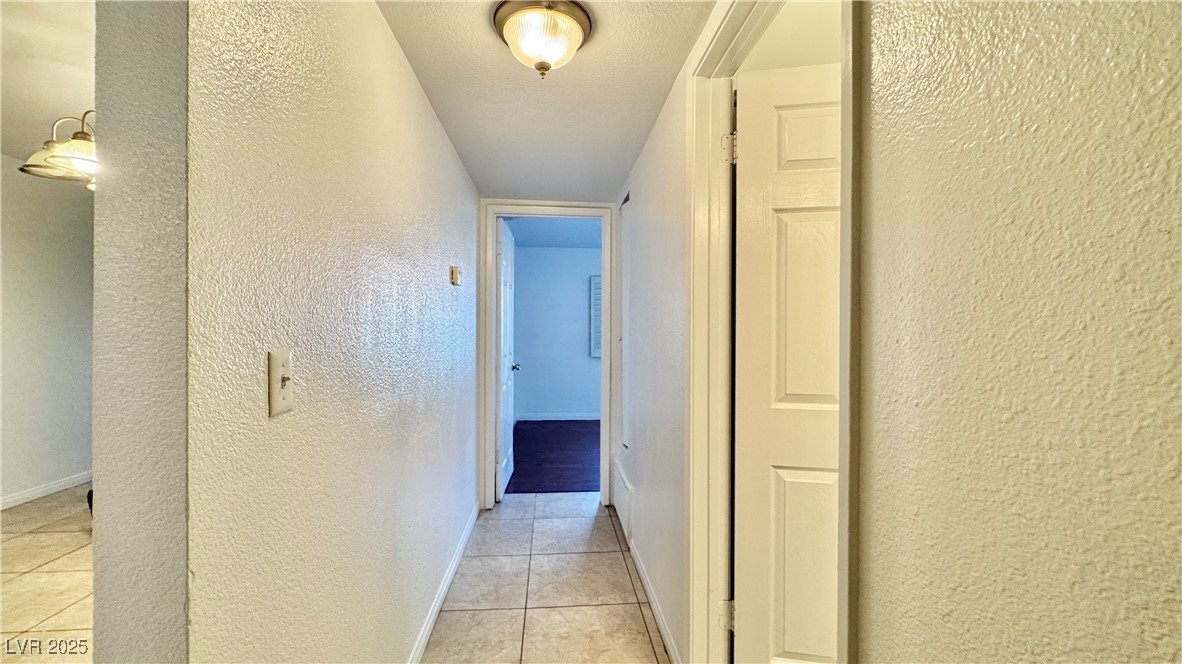 2750 South Durango Drive, Unit 2100 Las Vegas, NV 89117 - Photo 20 of 30 Hallway with a textured wall and light tile patterned floors