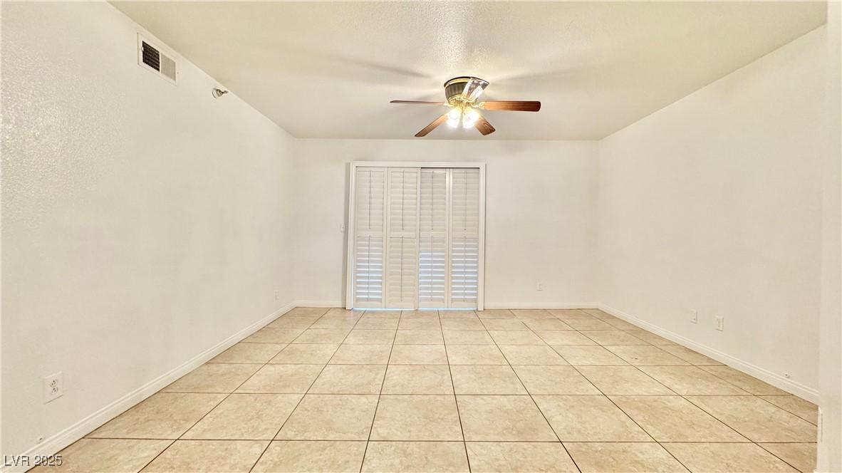 2750 South Durango Drive, Unit 2100 Las Vegas, NV 89117 - Photo 6 of 30 Empty room with a ceiling fan and light tile patterned flooring