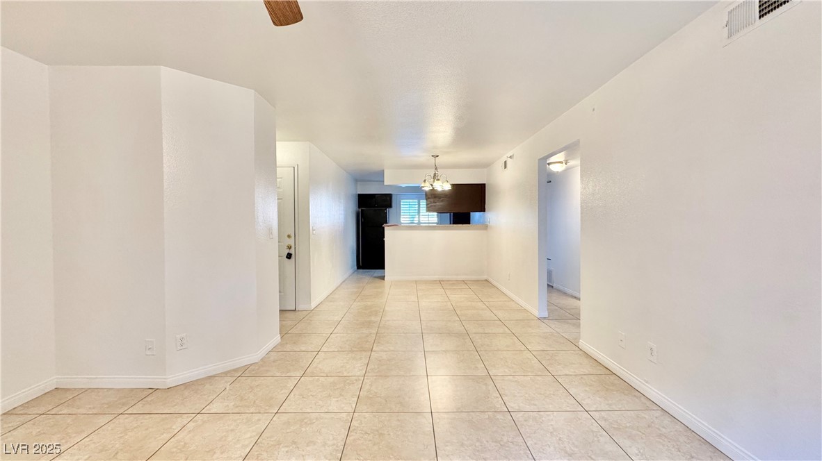 2750 South Durango Drive, Unit 2100 Las Vegas, NV 89117 - Photo 8 of 30 Unfurnished room with a chandelier and light tile patterned floors