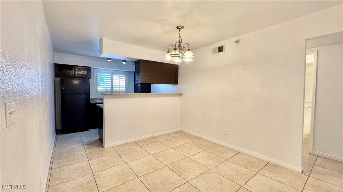 2750 South Durango Drive, Unit 2100 Las Vegas, NV 89117 - Photo 9 of 30 Unfurnished dining area featuring a chandelier and light tile patterned floors