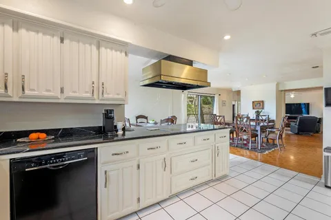 a kitchen with granite countertop white cabinets and stainless steel appliances