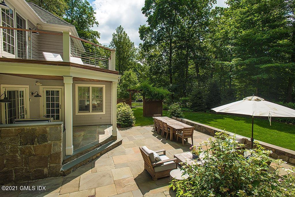 2 Carriage Road Cos Cob, CT 06807 - Photo 21 of 25 a backyard of a house with table and chairs under an umbrella