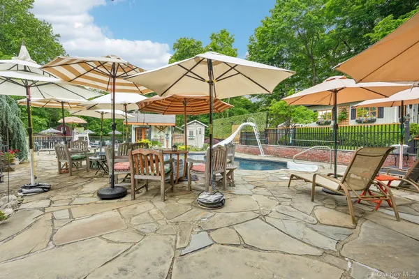 a view of patio with chairs and table under an umbrella
