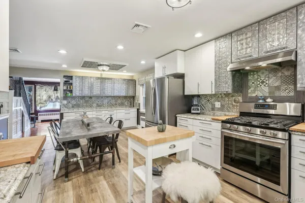 a kitchen with a stove a refrigerator and a dining table