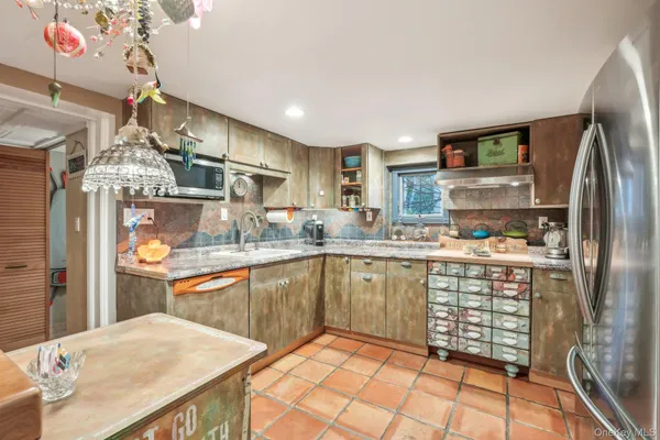 a kitchen with stainless steel appliances granite countertop a refrigerator and a sink