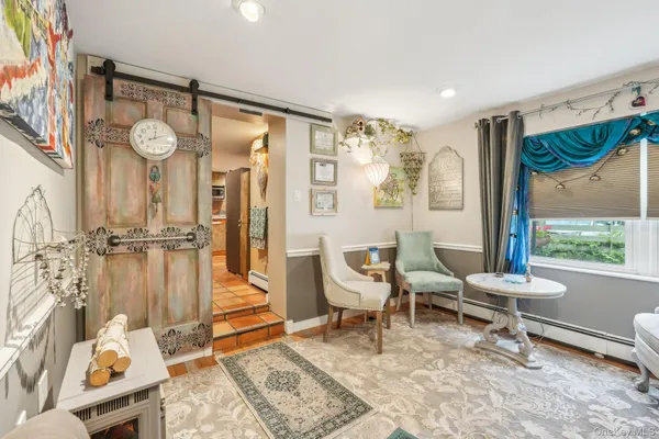 a living room with furniture a rug and a floor to ceiling window