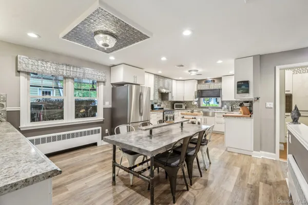 a kitchen with stainless steel appliances kitchen island granite countertop a refrigerator and microwave