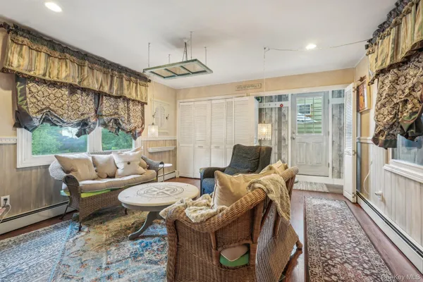 a living room with furniture a fireplace and a floor to ceiling window