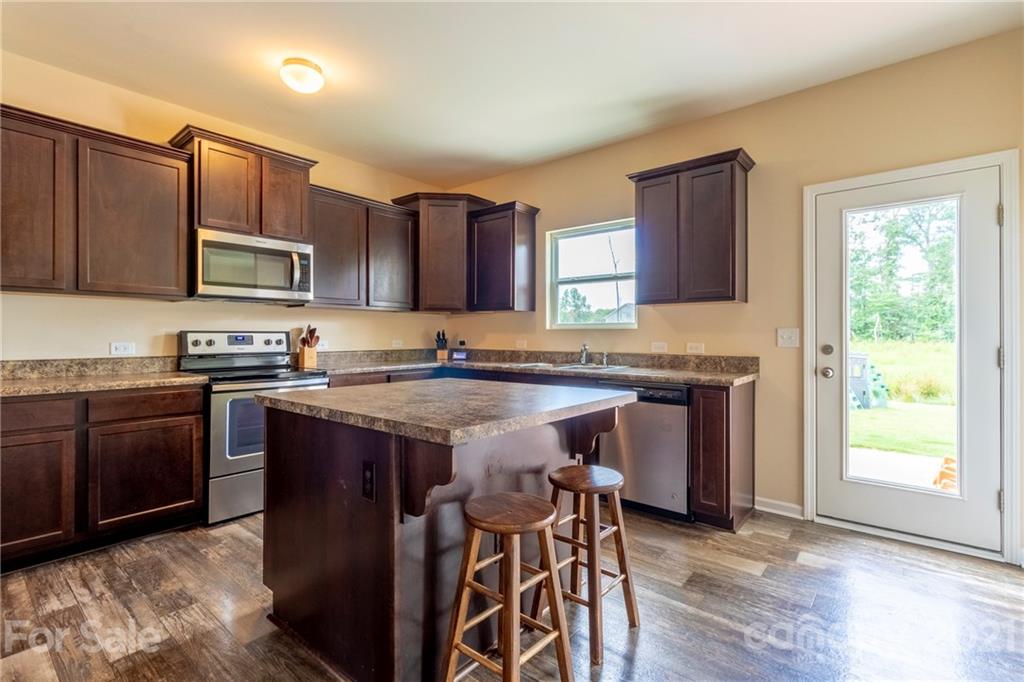 13010 Hill Pine Road Midland, NC 28107 - Photo 11 of 32 a kitchen with stainless steel appliances granite countertop a stove top oven a sink and dishwasher
