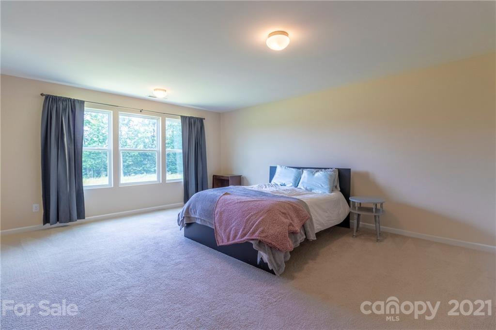 13010 Hill Pine Road Midland, NC 28107 - Photo 19 of 32 a spacious bedroom with a bed and a large window