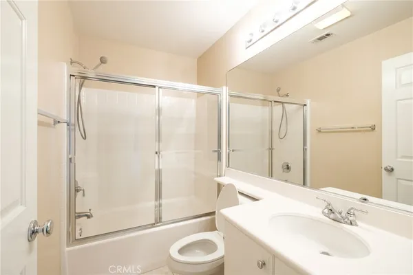 a bathroom with a sink and a mirror with shower