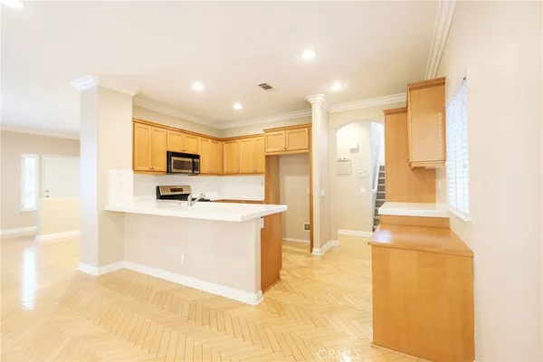 a view of kitchen with stainless steel appliances refrigerator stove microwave and sink