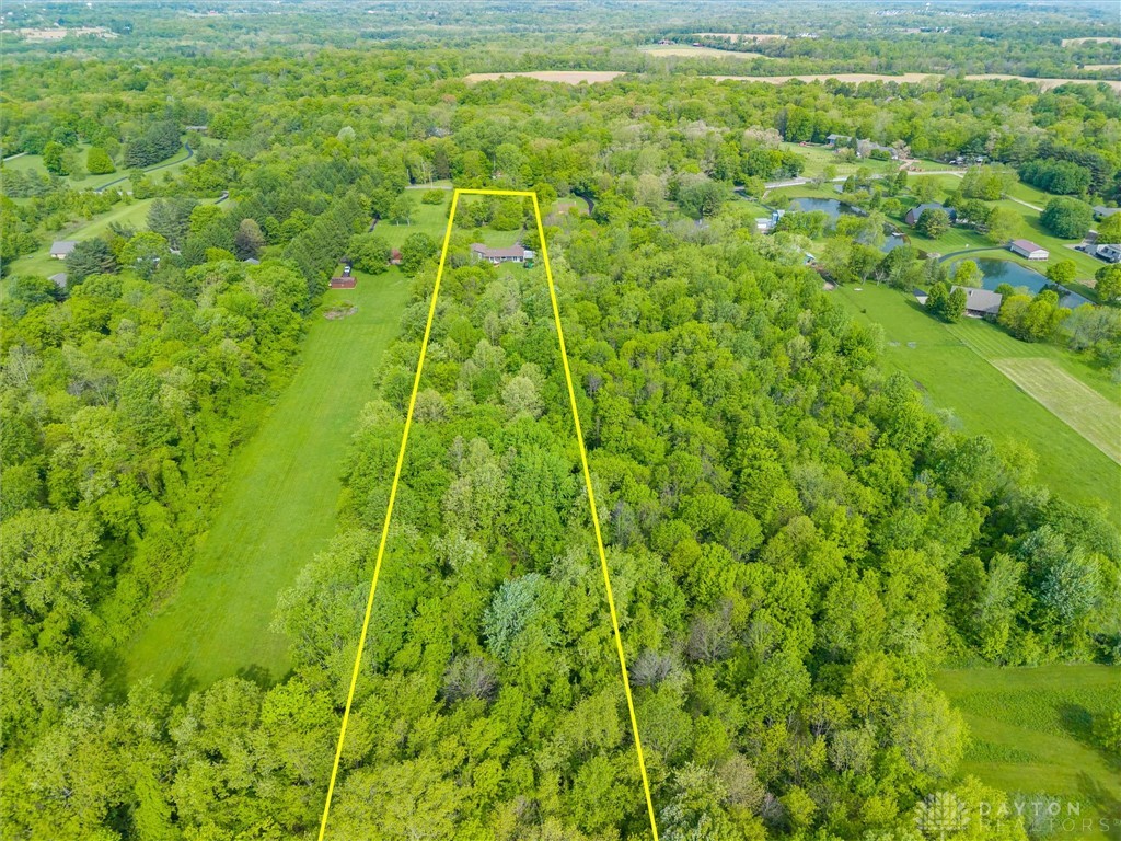 2165 Stewart Road Xenia, OH 45385 - Photo 41 of 59 This aerial view showcases a verdant lot with a residence nestled among lush trees and nearby water features.