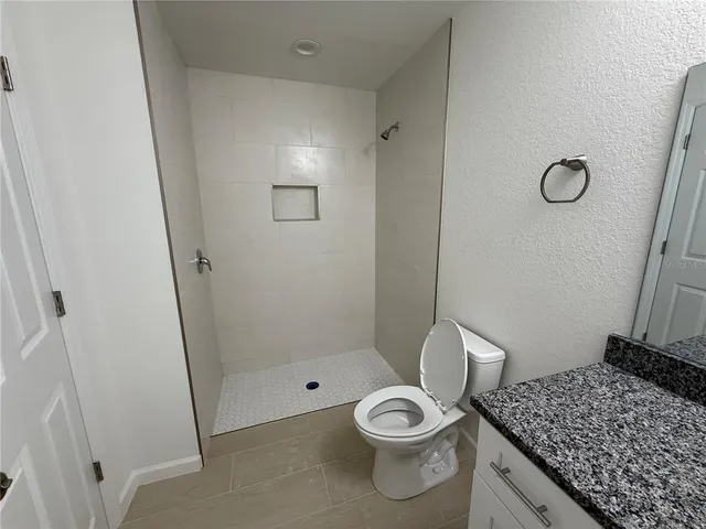a bathroom with a granite countertop sink toilet and shower