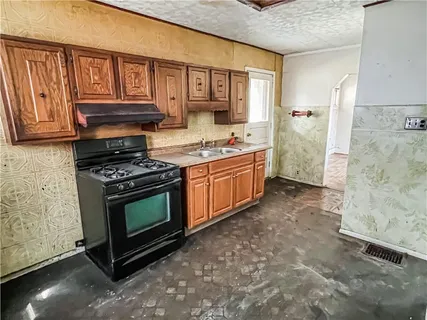 a kitchen with stainless steel appliances granite countertop a stove a sink and a refrigerator