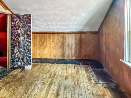 a view of an empty room with a window and a shower