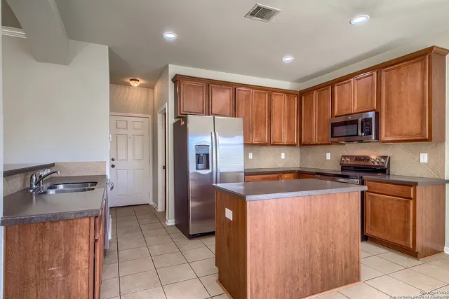 a kitchen with stainless steel appliances granite countertop a refrigerator stove microwave and sink