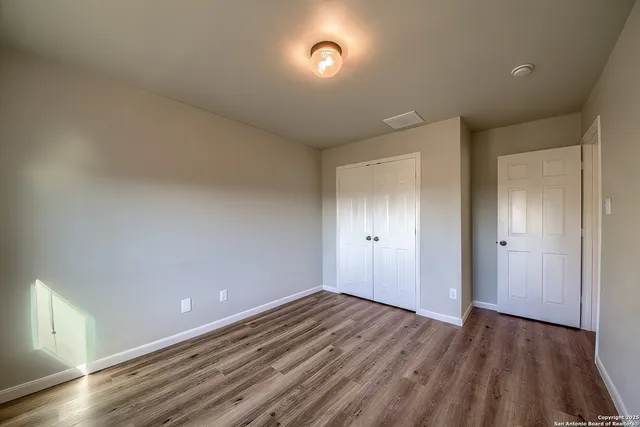 a view of an empty room and wooden floor
