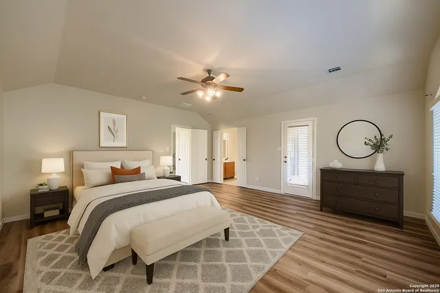 a spacious bedroom with a large bed and a chandelier