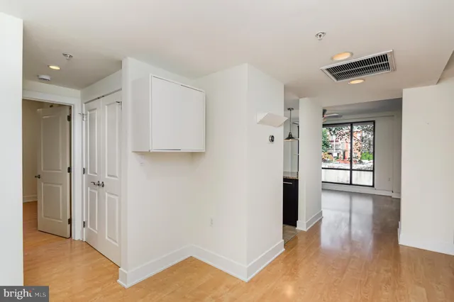a view of a hallway with wooden floor and closet