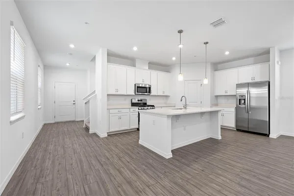 a view of kitchen with wooden floor and refrigerator