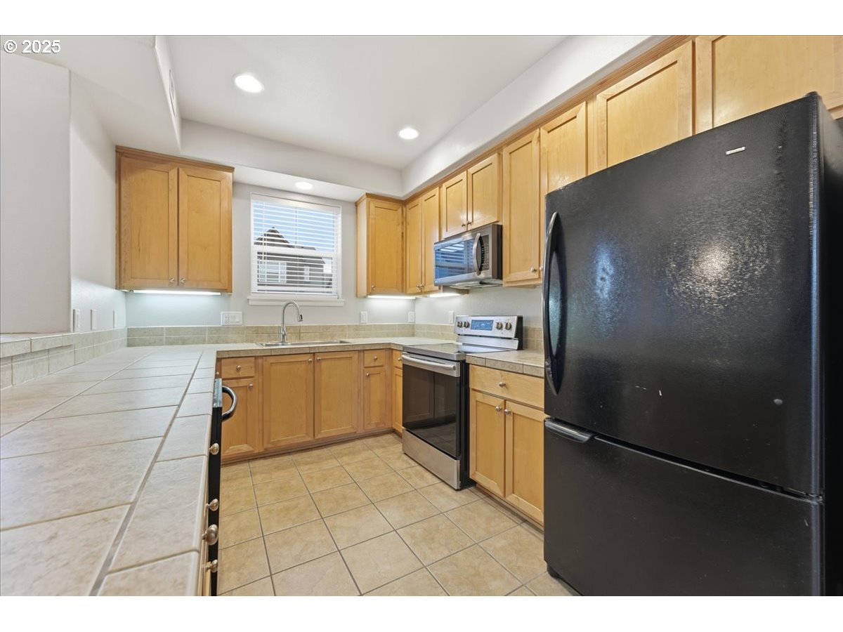 10835 Southwest Huntington Avenue Portland, OR 97223 - Photo 15 of 40 a kitchen with a refrigerator and a sink