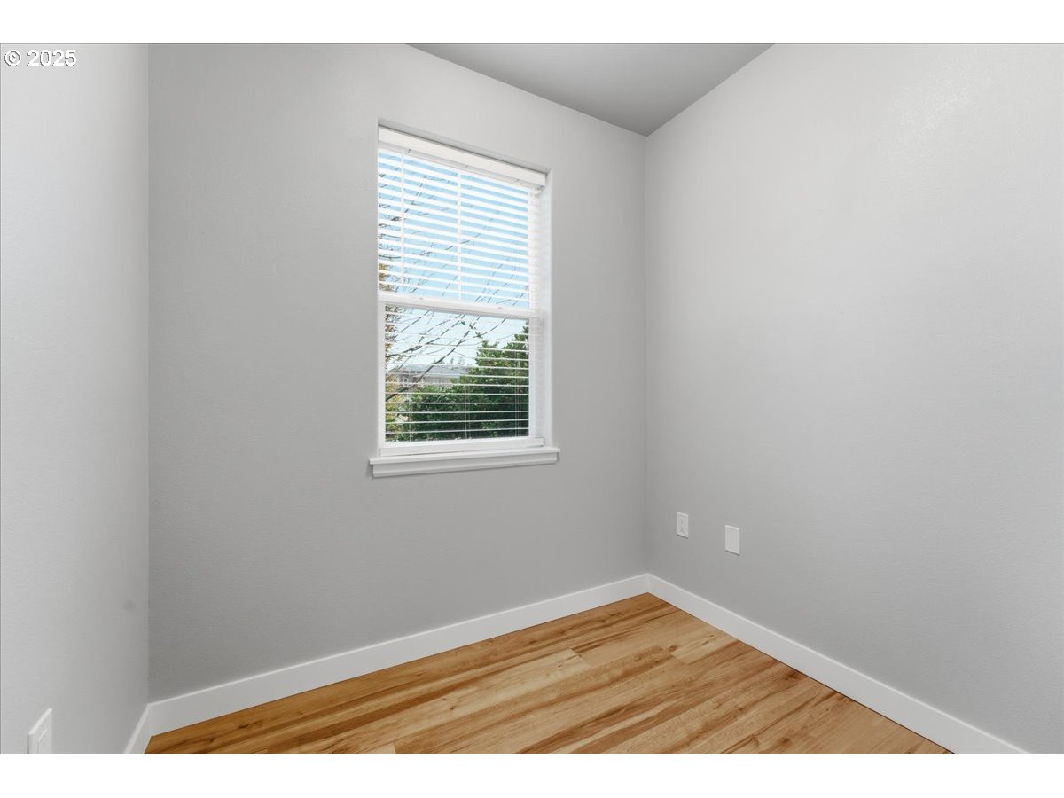 10835 Southwest Huntington Avenue Portland, OR 97223 - Photo 18 of 40 a view of an empty room with wooden floor and a window