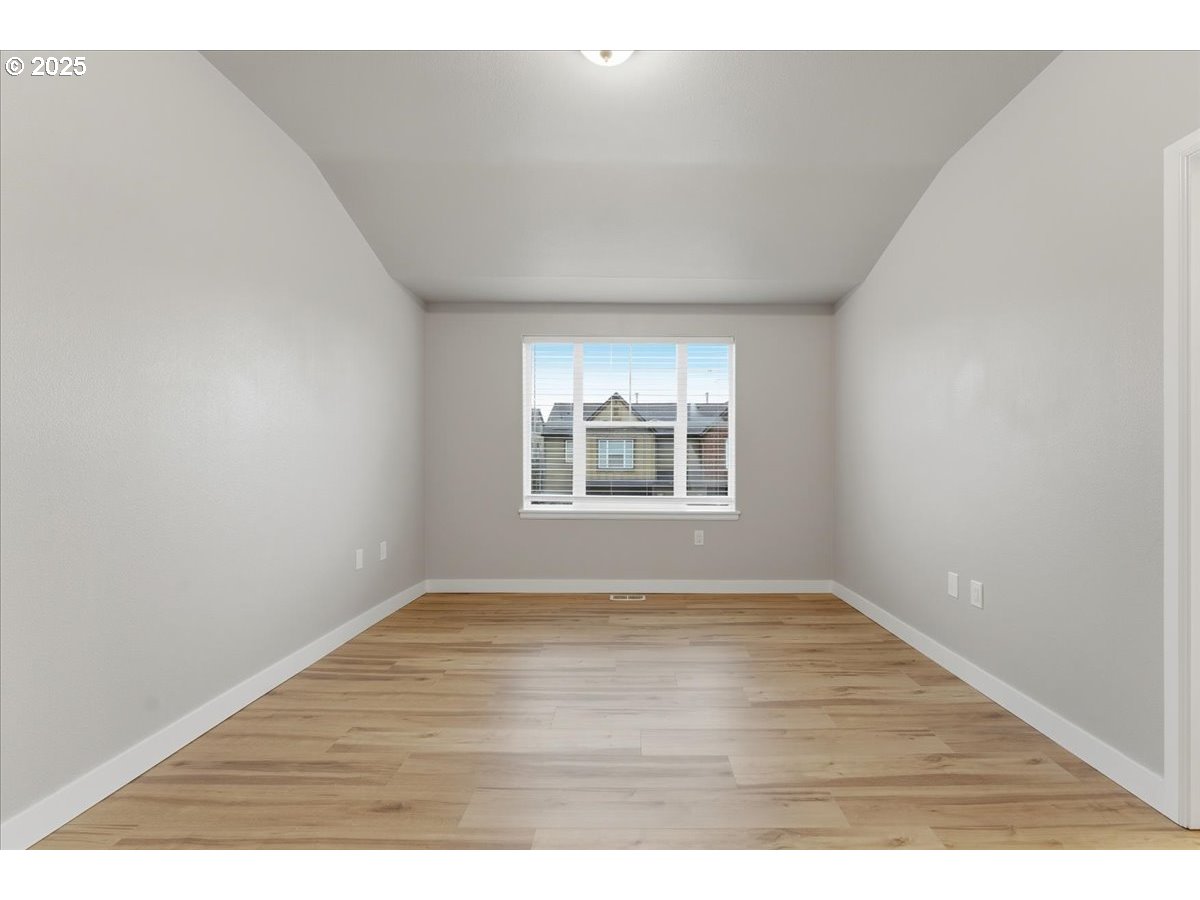 10835 Southwest Huntington Avenue Portland, OR 97223 - Photo 21 of 40 a view of an empty room with wooden floor and a window