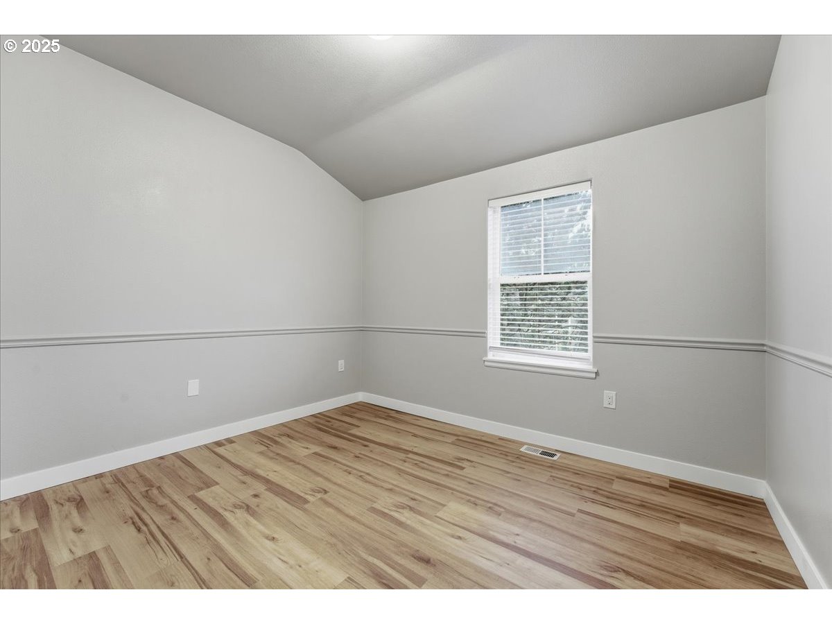 10835 Southwest Huntington Avenue Portland, OR 97223 - Photo 28 of 40 a view of an empty room with wooden floor and a window