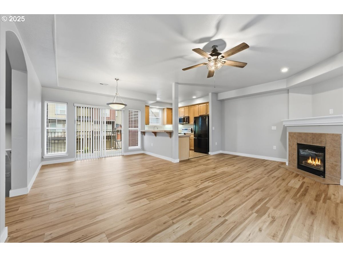 10835 Southwest Huntington Avenue Portland, OR 97223 - Photo 8 of 40 a view of a livingroom with wooden floor a ceiling fan and windows