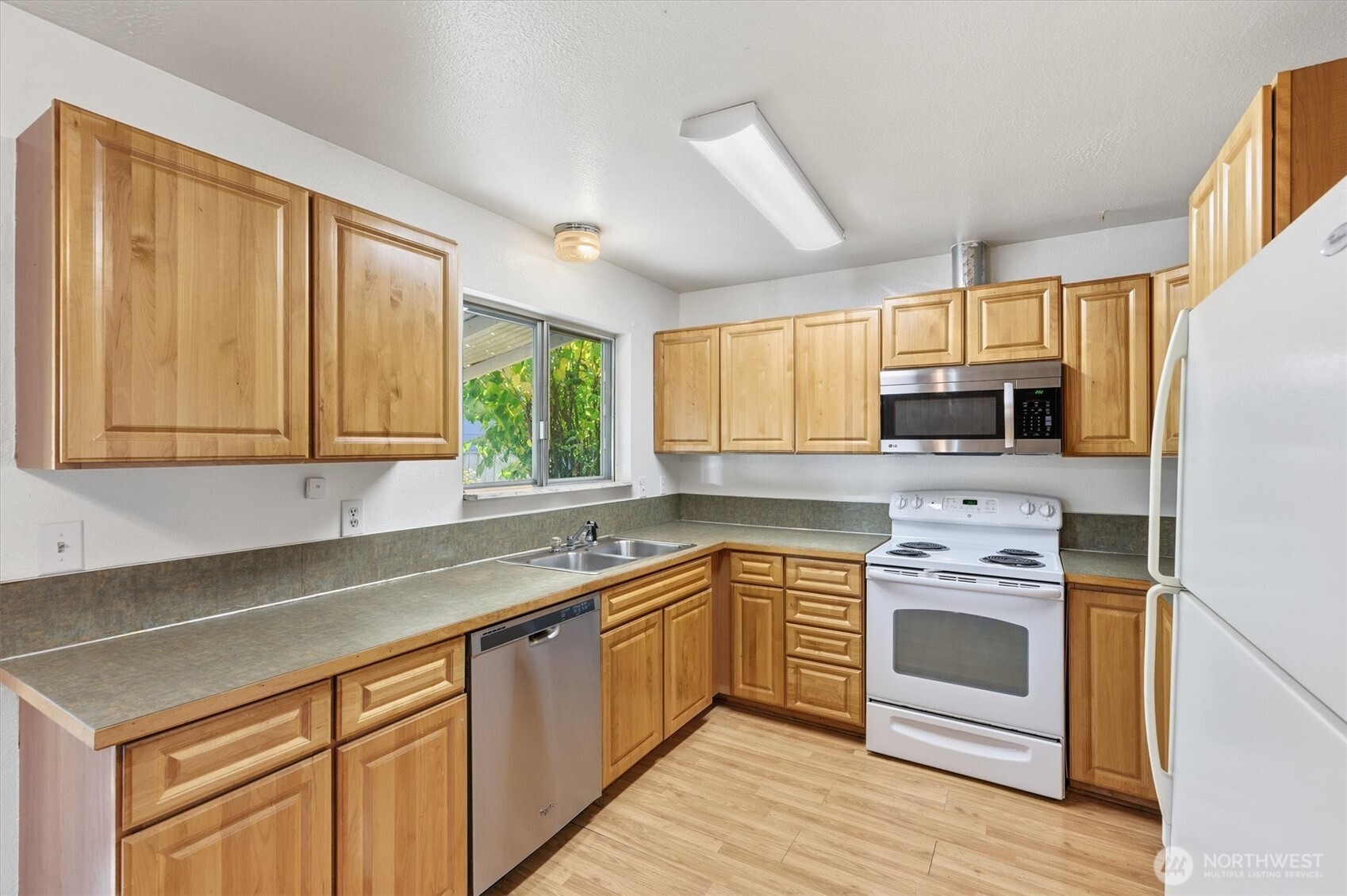 4759 Windemere Street Longview, WA 98632 - Photo 5 of 38 a kitchen with stainless steel appliances granite countertop white cabinets a sink a stove a refrigerator with grey cabinets and wooden floor