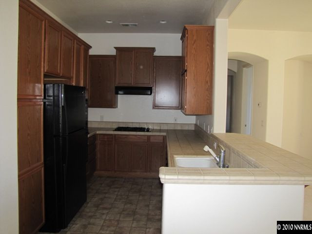 9900 Wilbur May Parkway, Unit 3405 Reno, NV 89521 - Photo 6 of 12 a kitchen with a sink a refrigerator and cabinets