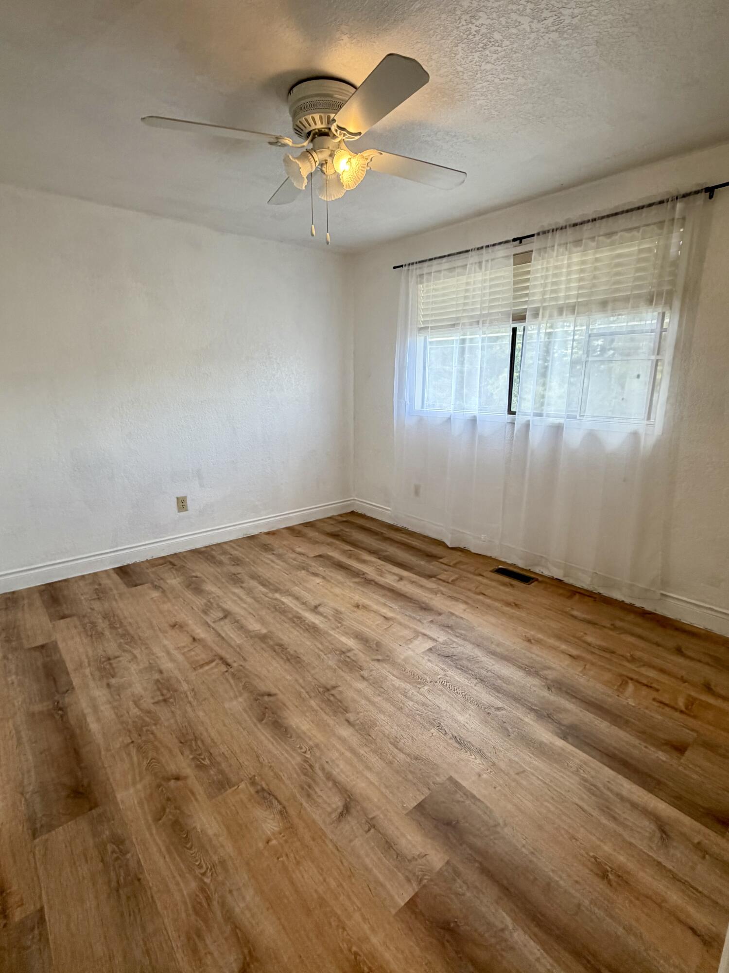 1198 Morrow Road, Unit A Medford, OR 97504 - Photo 14 of 20 an empty room with a window and a ceiling fan