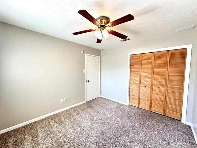 a view of an empty room with a ceiling fan